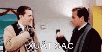 two men are talking to each other in a room with the words xuat sac written on the bottom of the image .