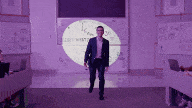 a man in a suit is walking in front of a white board that says " i am 30 "