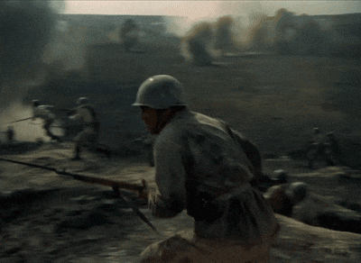a man in a helmet is holding a rifle in a battlefield