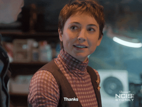 a woman in a plaid shirt is smiling and says thanks