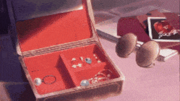 a red jewelry box filled with jewelry and sunglasses
