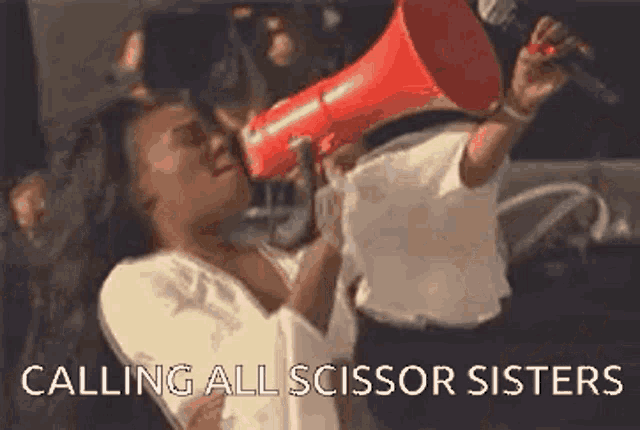 a woman is holding a red megaphone in her hand and shouting into it .