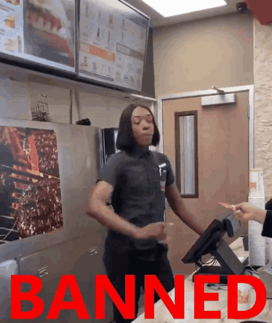 a woman is dancing in a fast food restaurant with the word banned behind her