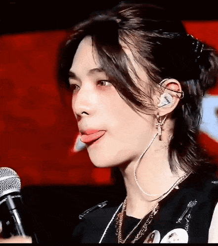 a close up of a person sticking their tongue out while holding a microphone .