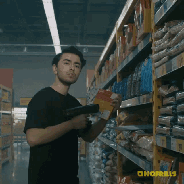 a man is standing in a grocery store with the word deals behind him