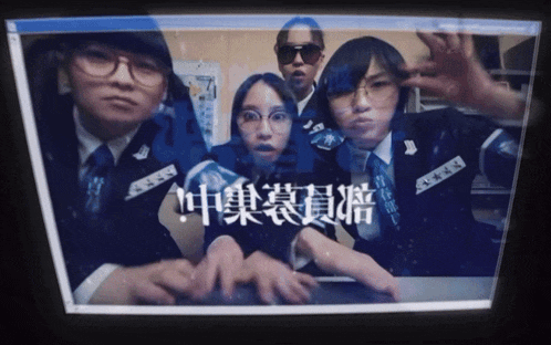 a group of people standing in front of a computer screen with chinese writing