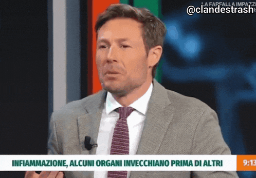 a man in a suit and tie is talking on a news channel