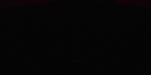 a red light is shining on a dark background