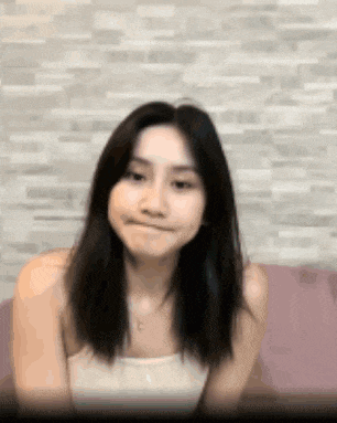 a woman is sitting on a couch making a funny face .