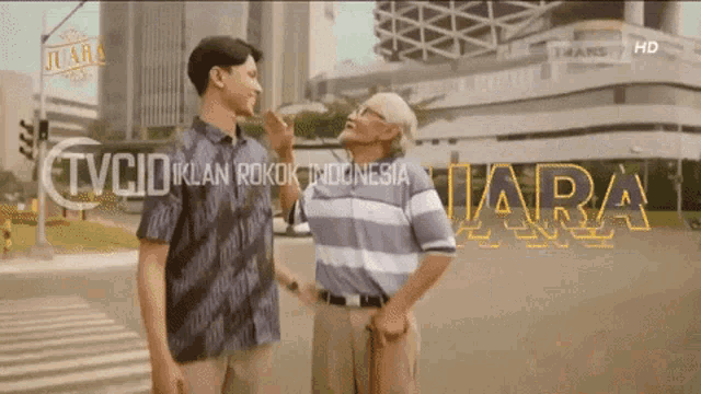 a man and an older man are standing next to each other in front of a building that says tvciiklan rokok indonesia