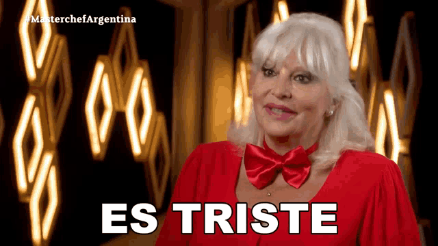 a woman in a red dress and bow tie says " es triste "