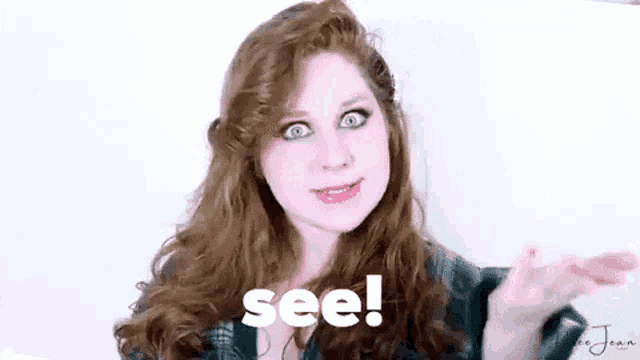 a woman with red hair is making a funny face and saying see !