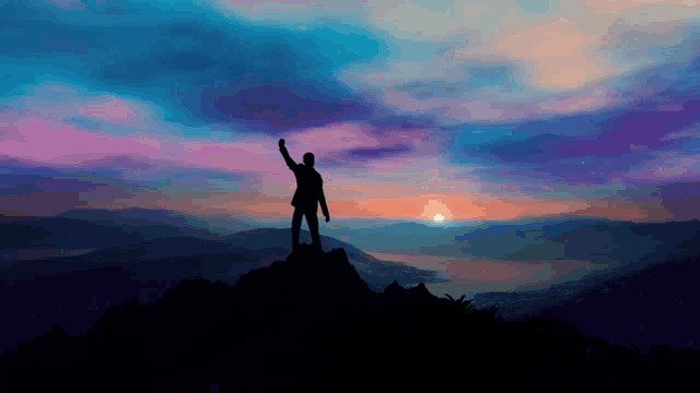 a silhouette of a man standing on top of a mountain with his arm in the air