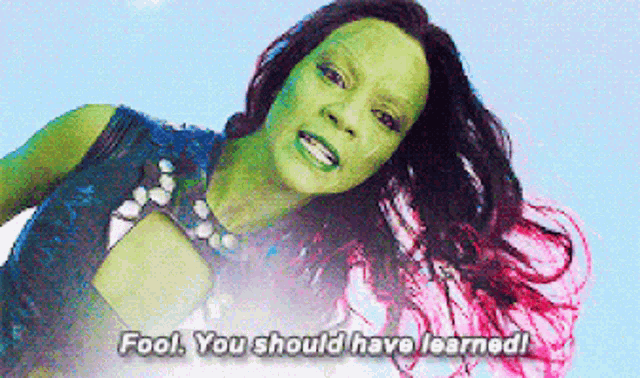 a woman with a green face and pink hair says fool you should have learned