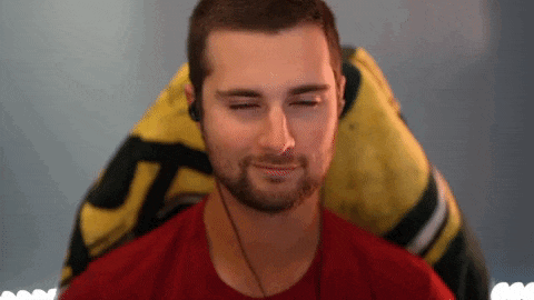 a man with a beard is sitting in a gaming chair with his eyes closed and smiling .
