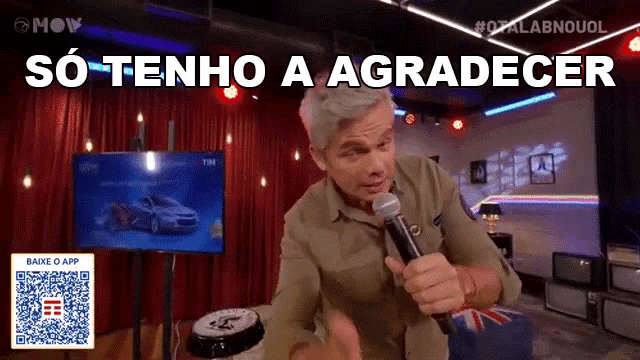 a man singing into a microphone with the words so tenho a agradecer written above him