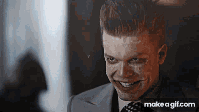 a man in a suit and tie is smiling with make a gif.com in the lower right corner