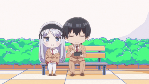 a boy and a girl are sitting on a bench looking at their phones
