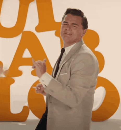 a man in a suit and tie is dancing in front of a sign that says u.a.b.