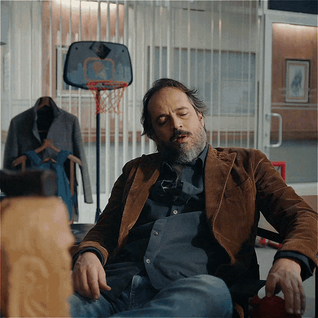a man sitting in front of a basketball hoop