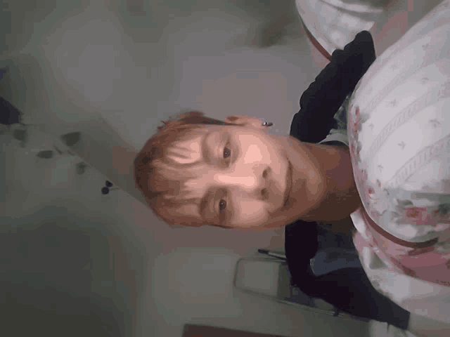 a young boy laying on a bed with a floral shirt on