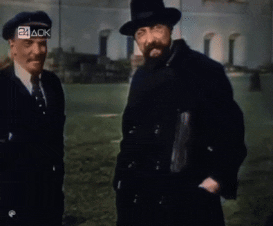 two men are standing in front of a building with the letters 24 ack visible