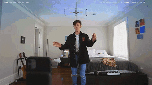 a young man is dancing in a bedroom with a keyboard and a phone