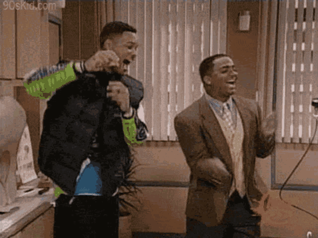 two men in suits are dancing in a room .