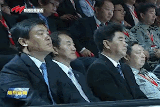a group of men in suits and ties are sitting in a stadium watching a sports game