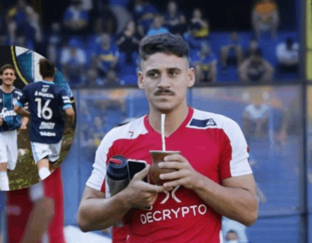 a man in a red decrypto jersey drinks from a cup