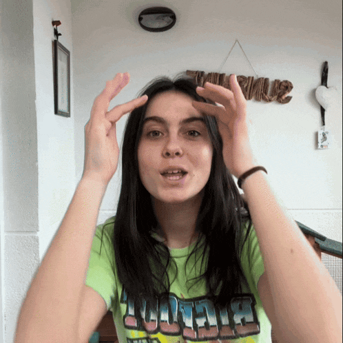 a woman wearing a green shirt that says biggie is making a funny face
