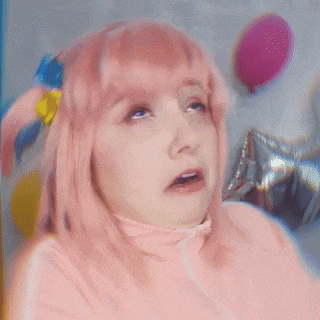 a woman in a pink wig is making a funny face