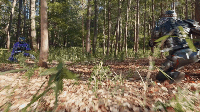 a man in a blue suit is running through a forest