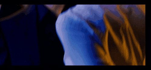 a close up of a man and woman kissing in a dark room