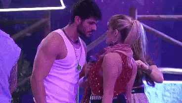 a man and a woman are standing next to each other in a room .