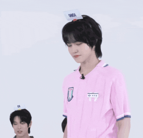 a man wearing a pink shirt and a hat with the word onion on it