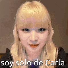 a woman with blonde hair is making a funny face and saying `` soy solo de carla '' .