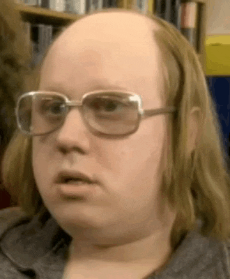 a close up of a bald man wearing glasses and a gray shirt .