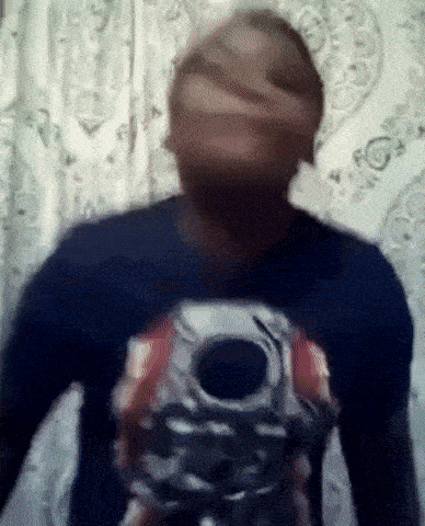 a man in a blue shirt is holding a gun in his hand .