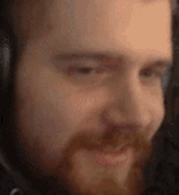 a close up of a man 's face with a beard and headphones .