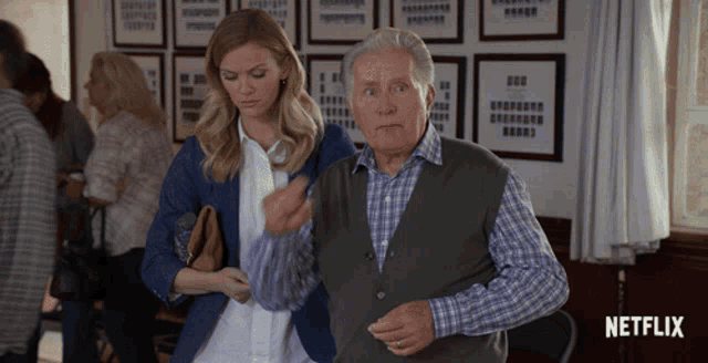 a man and a woman are standing next to each other with a netflix logo in the corner
