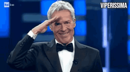 a man wearing a tuxedo and bow tie salutes with the words viperissima behind him