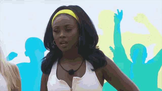 a woman in a white tank top with a yellow headband