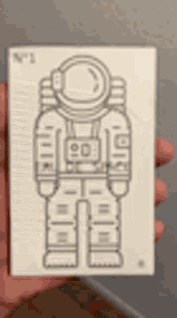 a person is holding a card with a picture of an astronaut on it
