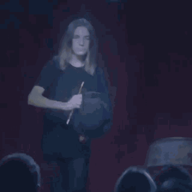 a woman is holding a teddy bear in her hands in the dark .