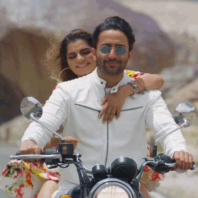 a man and a woman are riding a motorcycle