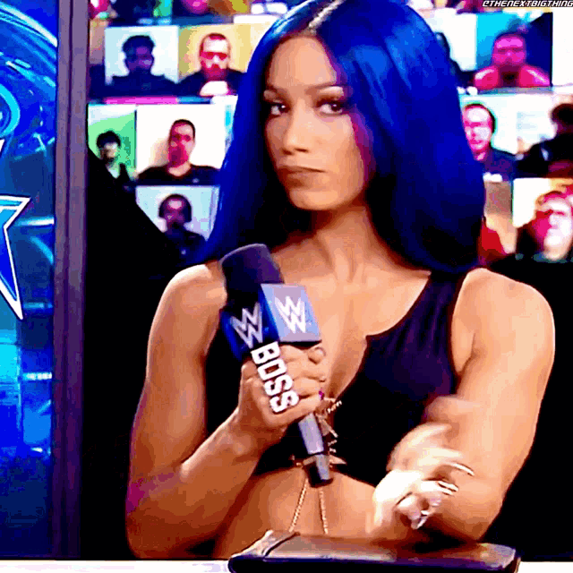 a woman with blue hair holds a microphone that says boss