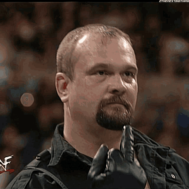 a man with a beard is wearing a black jacket and a black glove