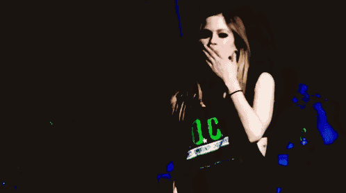a woman blowing a kiss while holding her hand to her face