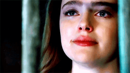 a close up of a woman 's face with a tear running down her face